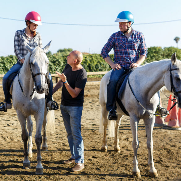 Trainer talking to woman while riding horse at farm Trainer talking to woman while riding horse at farm outdoor